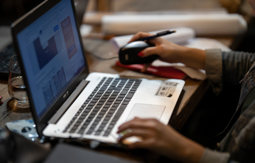 supervisor approving reports on laptop