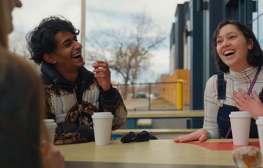 two students laughing over coffee