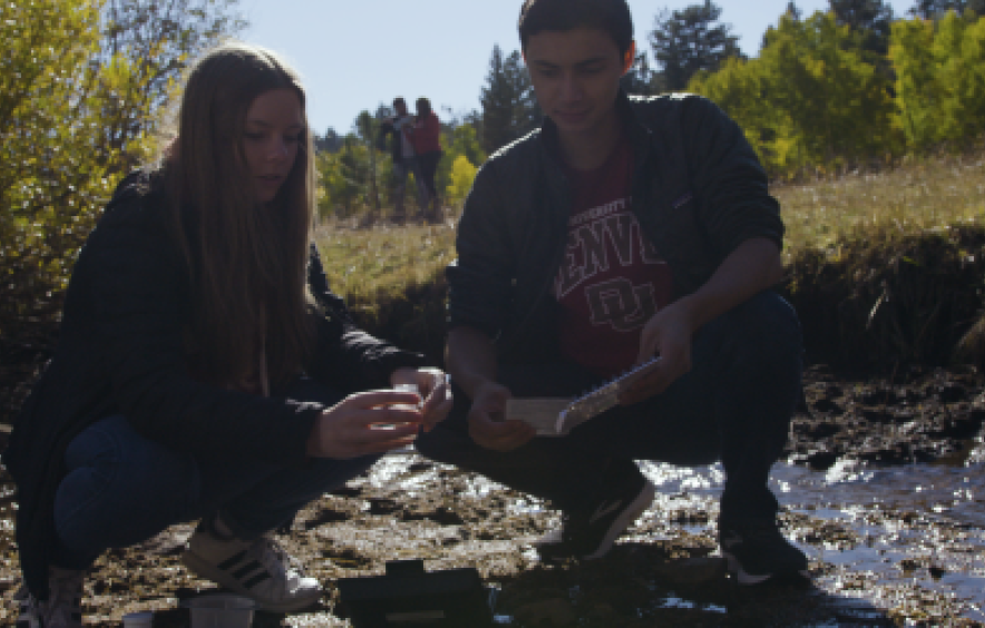 two students in a creekbed