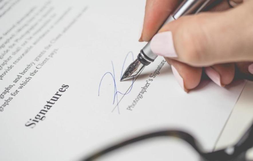 Photo of signing a contract with a pen