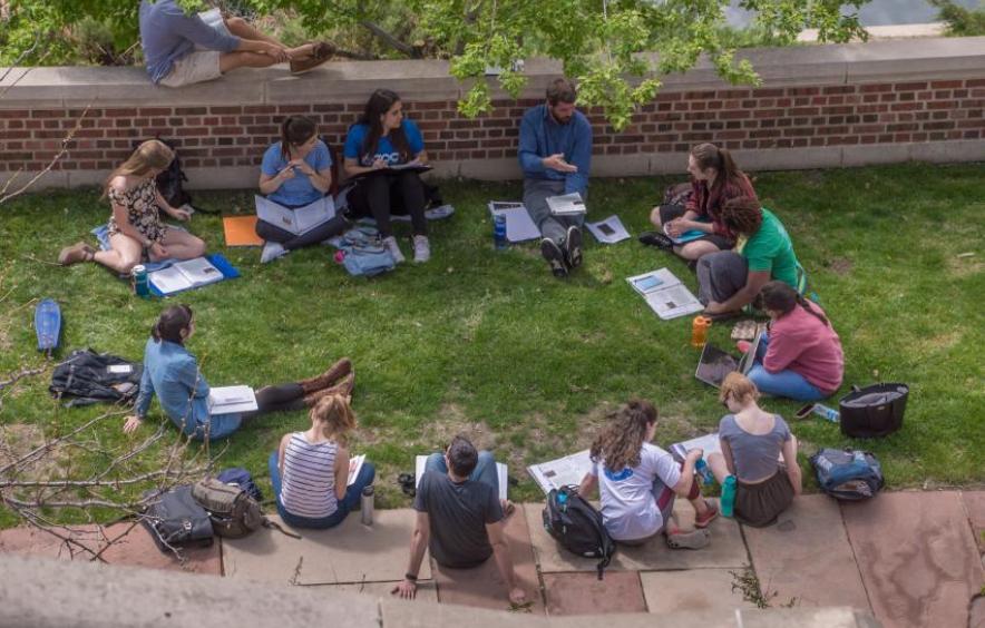 group of students sitting outdoors in circle