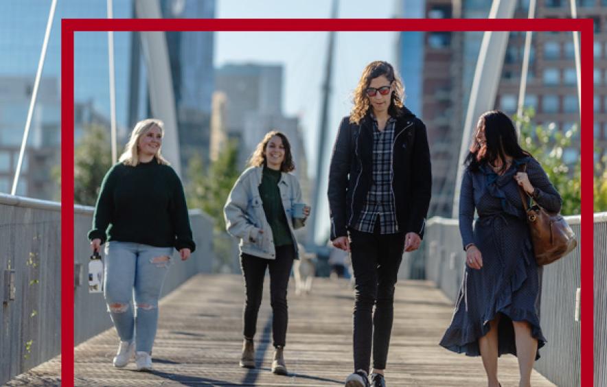four students walking across bridge