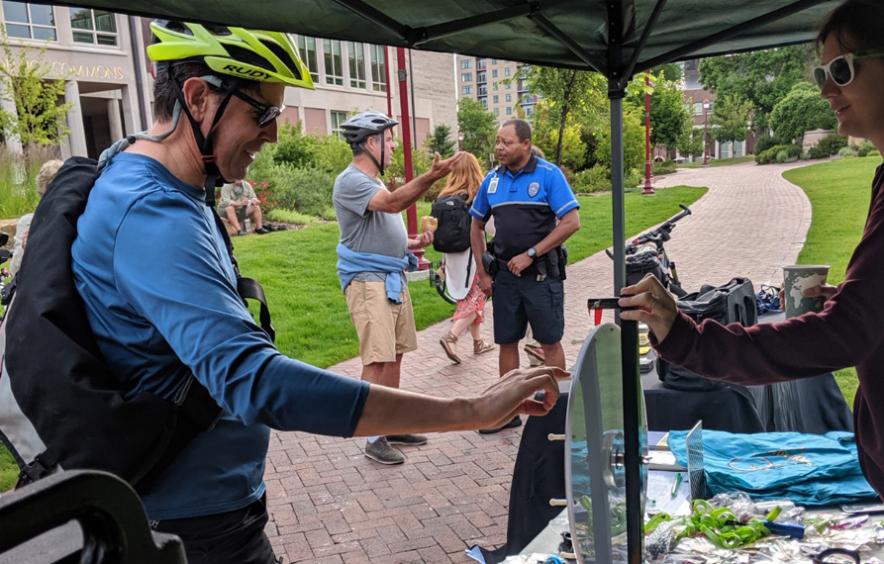 cyclist standing next to promo table on campus