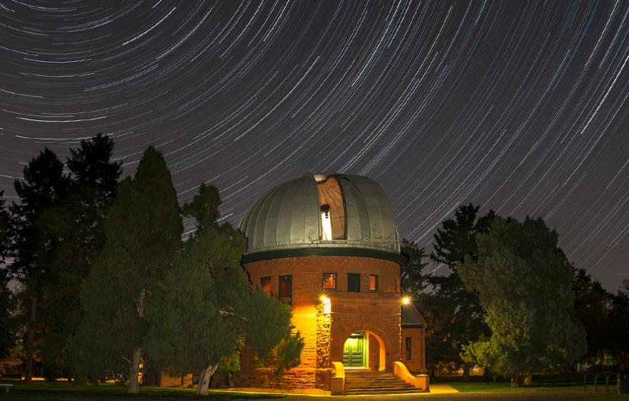 The Chamberlin Observator, an astronomical observatory in Observatory Park against the night sky. 