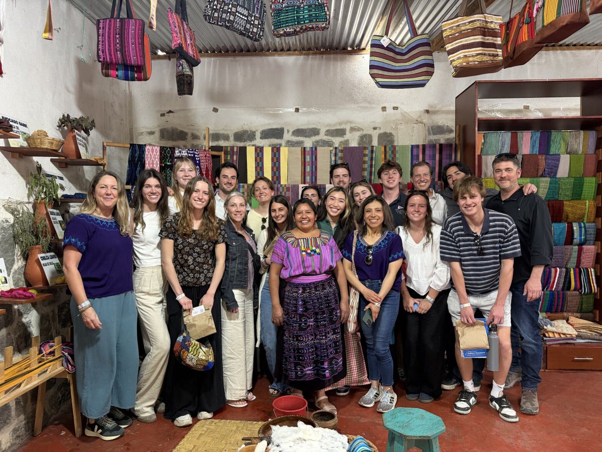 A group of DU students posing in a shop in Guatemala during an interterm trip