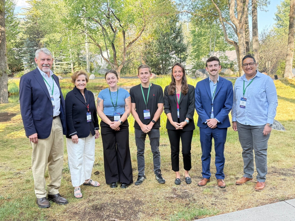 Four students pose for a group photo with three faculty members. 