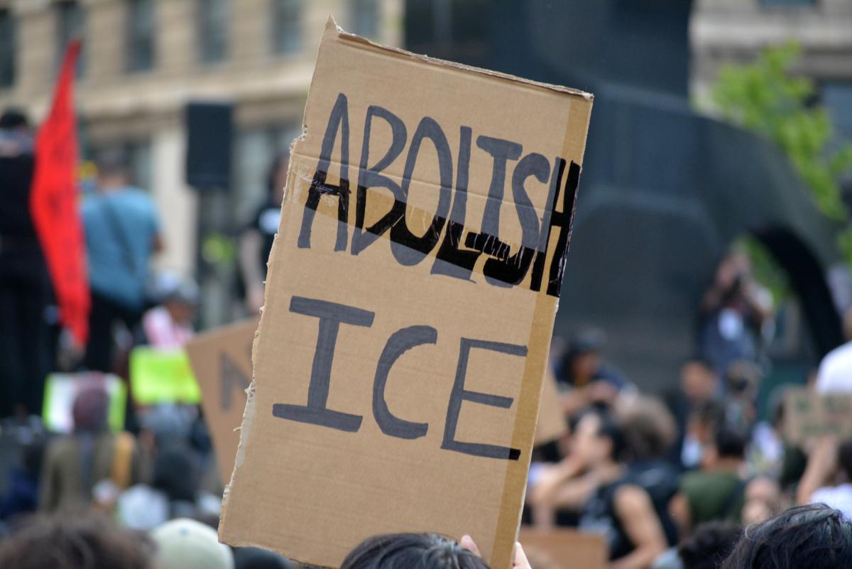 cardboard sign that says abolish ICE