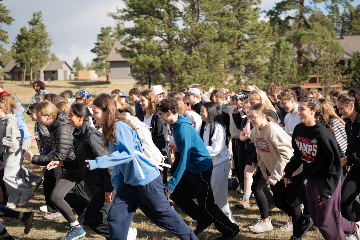 A large crowd of students runs in a field.