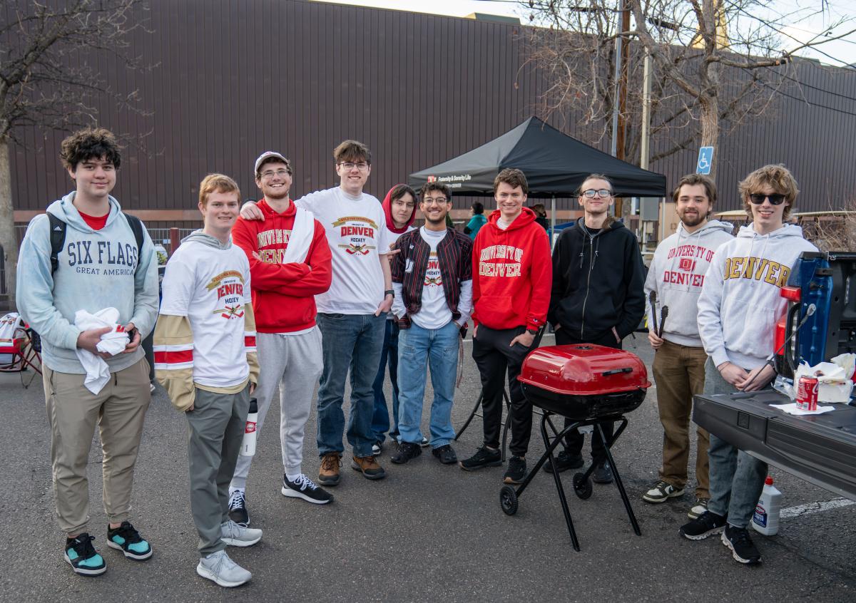 students around grill at hockey tailgate