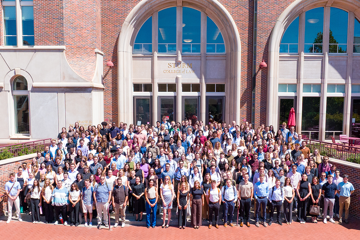 More than 200 incoming students stand for a group photo outside the Ricketson Law Building.