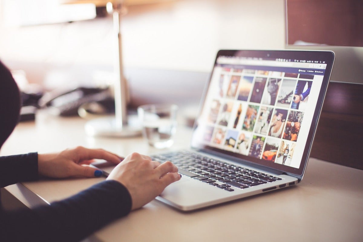 stock image of hands working on a laptop 
