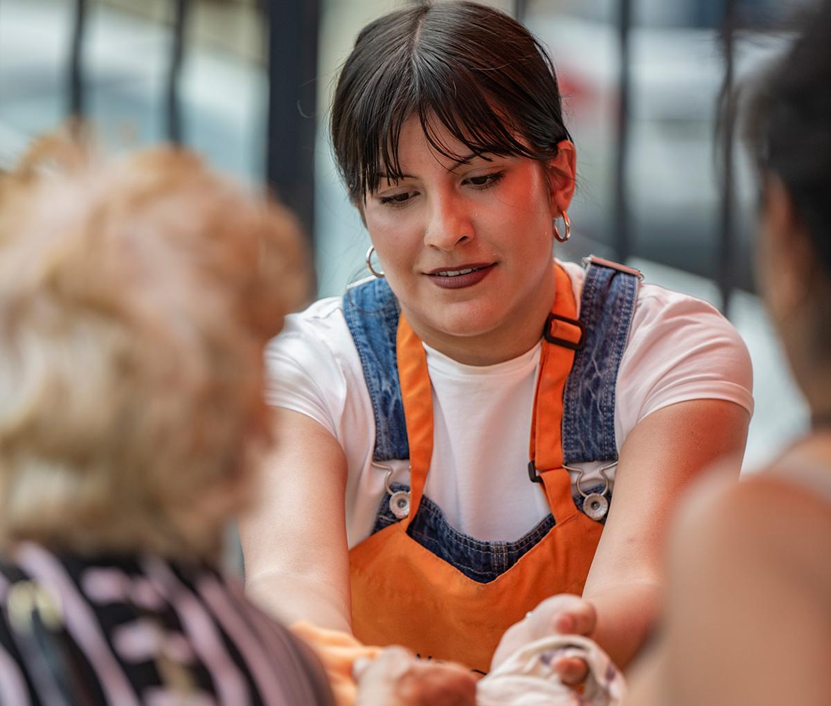 a student handing things to two people