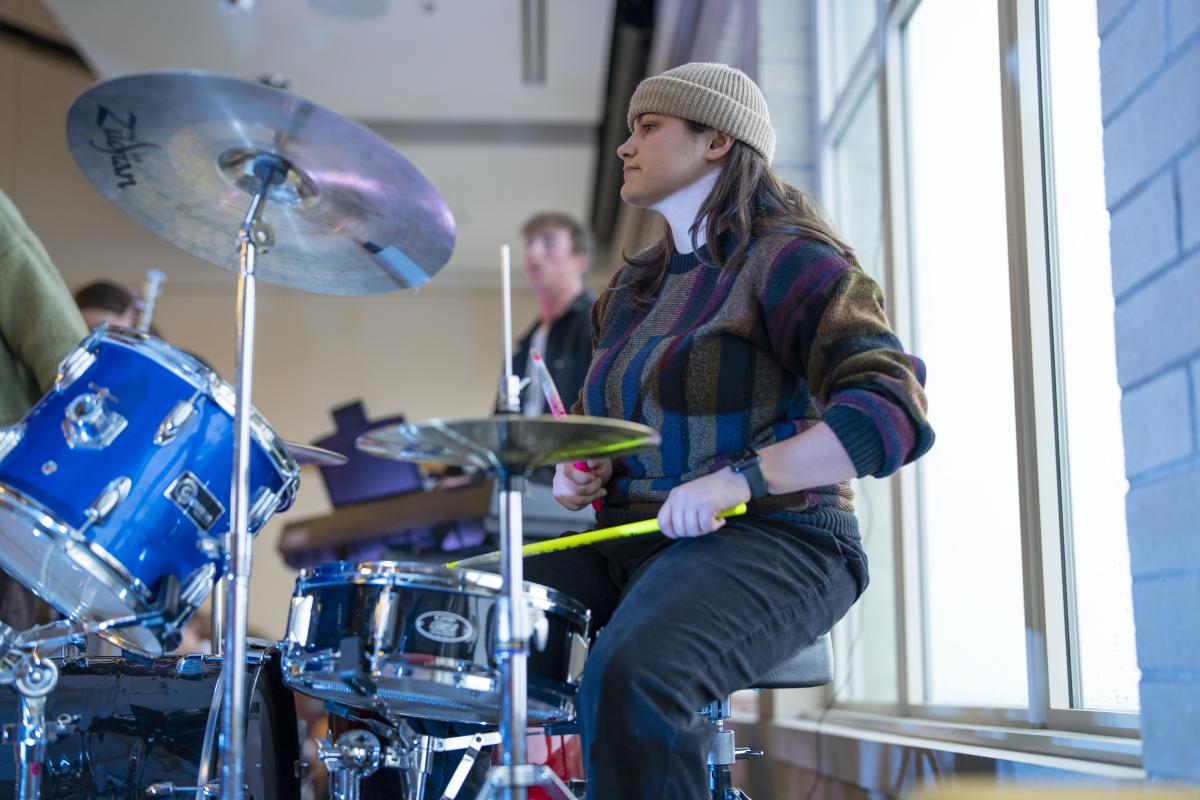 A student hits the drums.