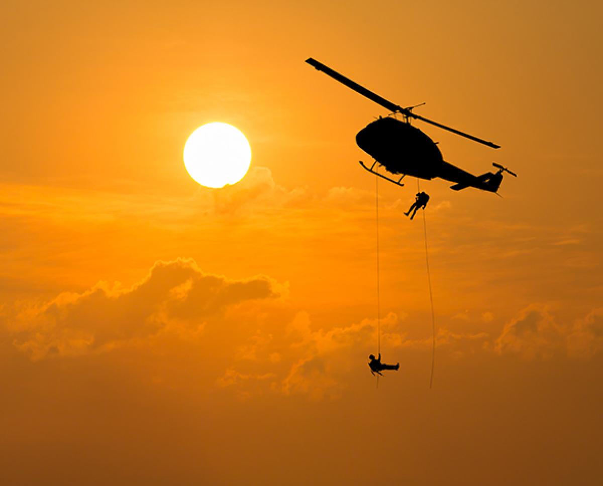A helicopter with air rescue soldiers hanging out