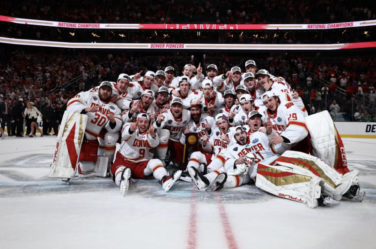 DU's mens hockey team poses for a photo on the ice, celebrating their most recent championship.