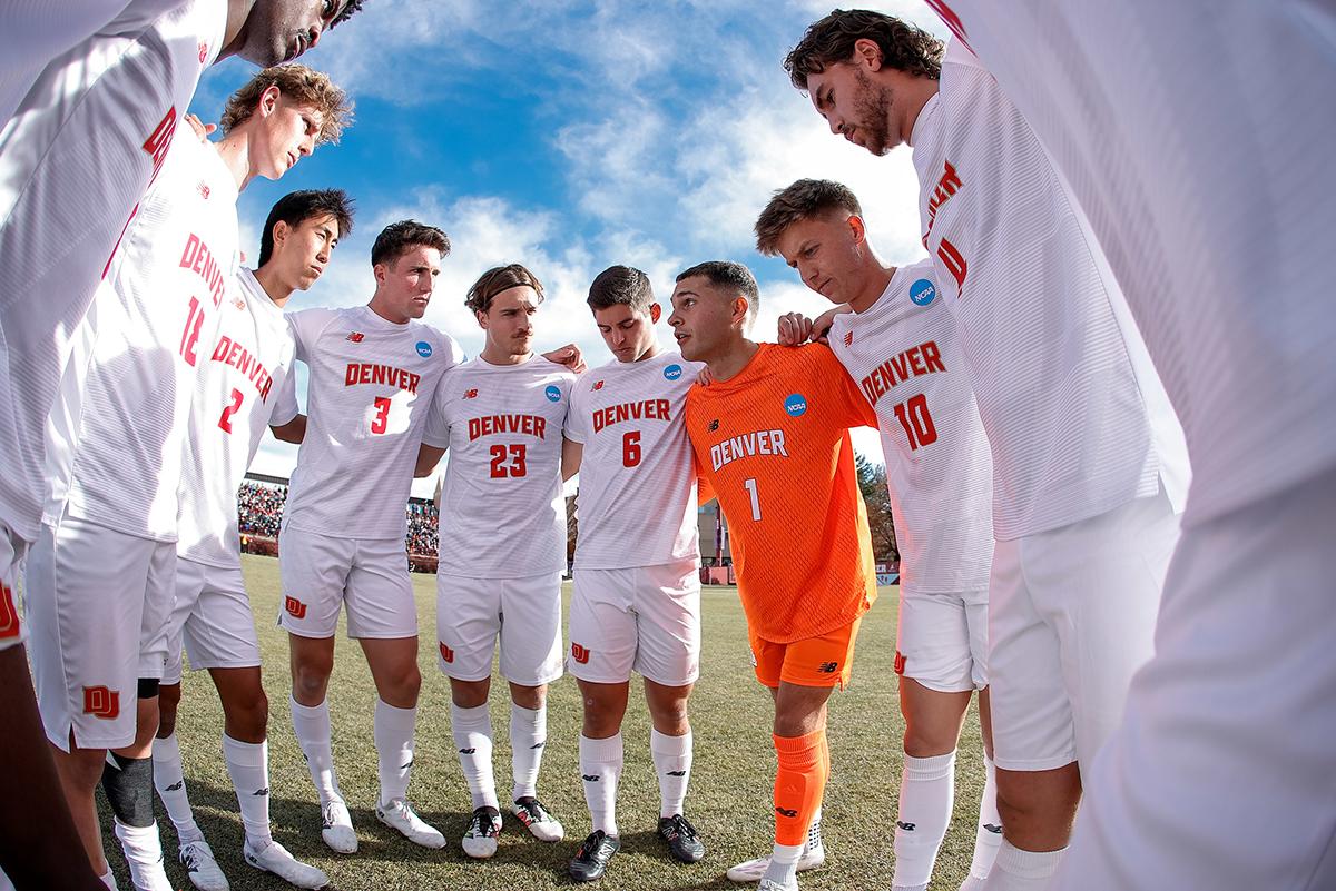 The DU men's soccer team huddles before the match against UMass.