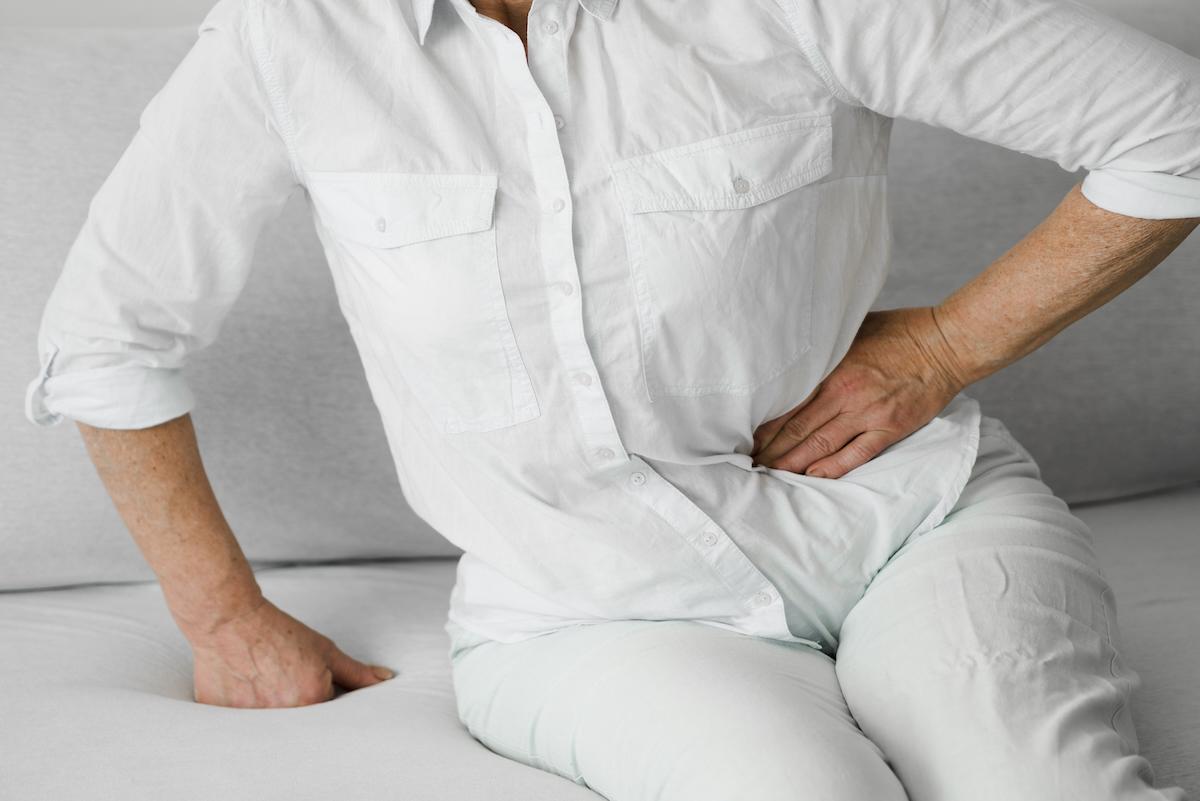 A patient on a couch holding their hip.
