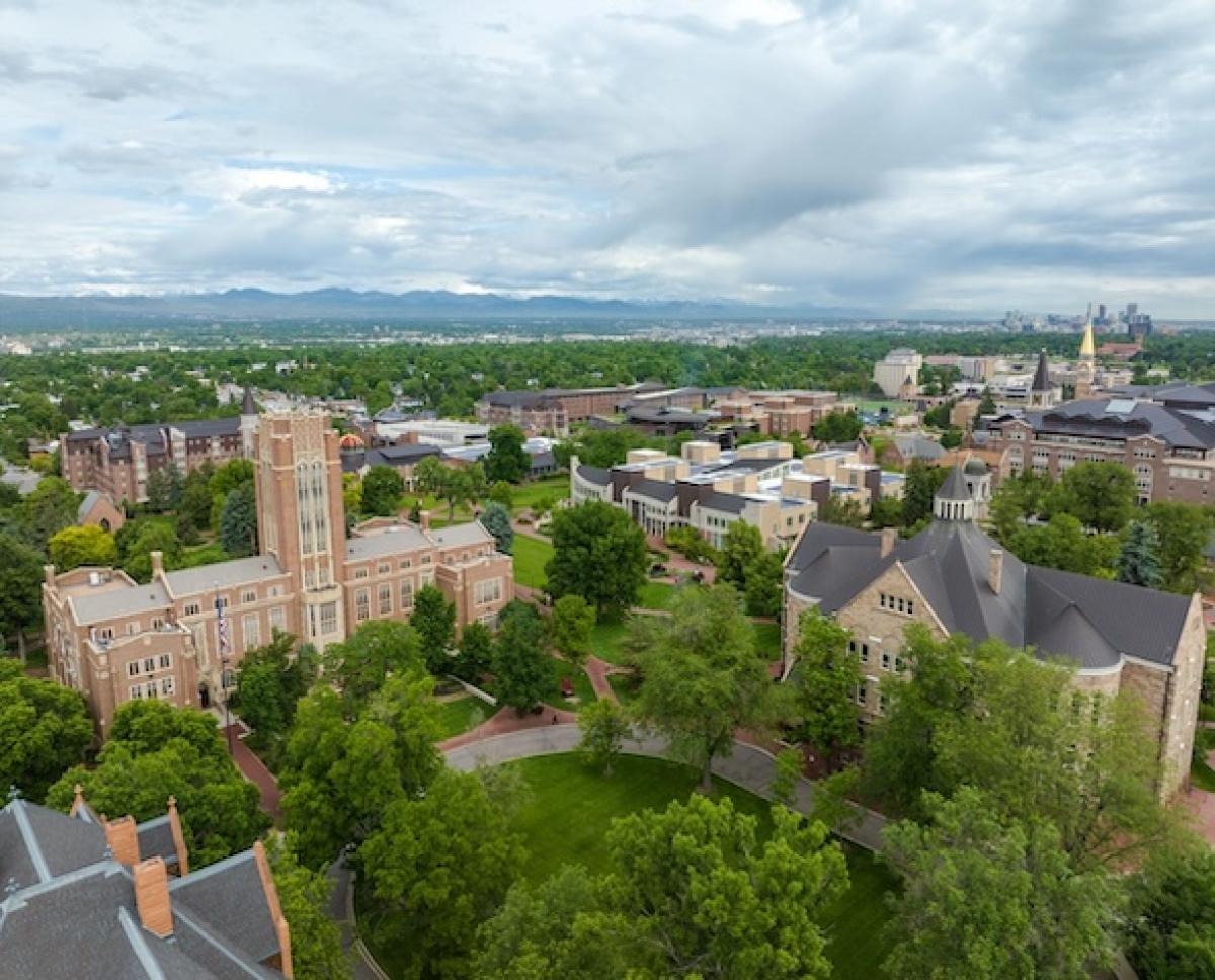 Aeiral view of DU campus with the Rocky Mountains and Denver skyline in the background