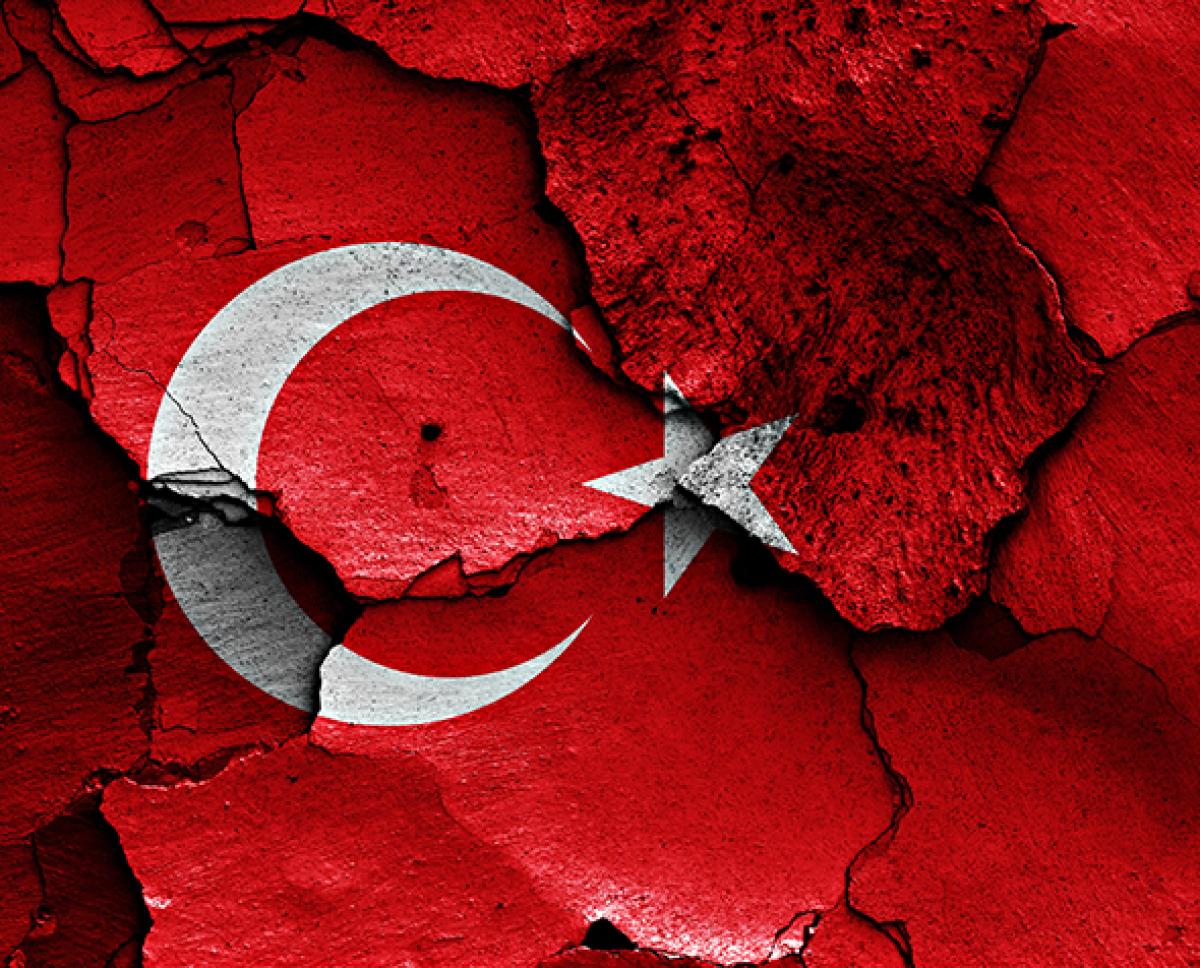Photo illustration of Turkish flag over cracked earth