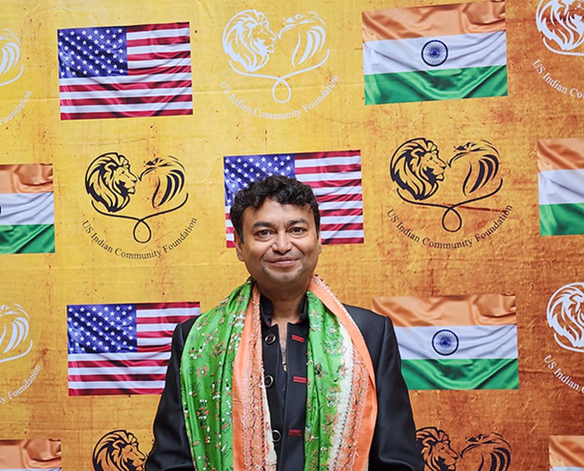 A man posed in front of a backdrop