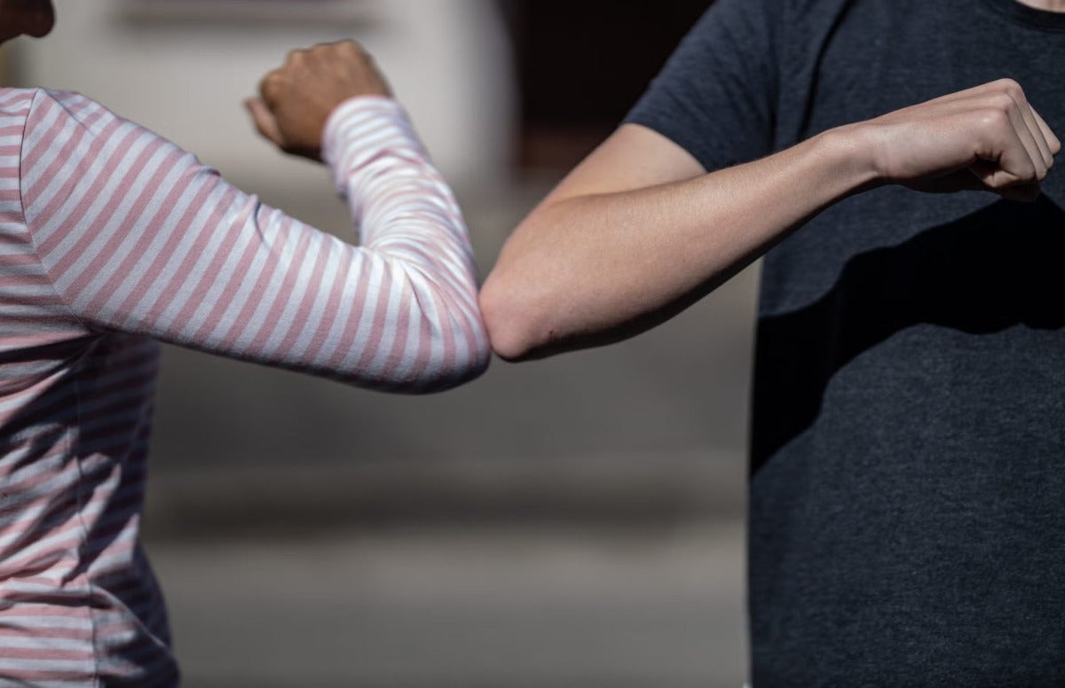 people cheer each other by touching elbow