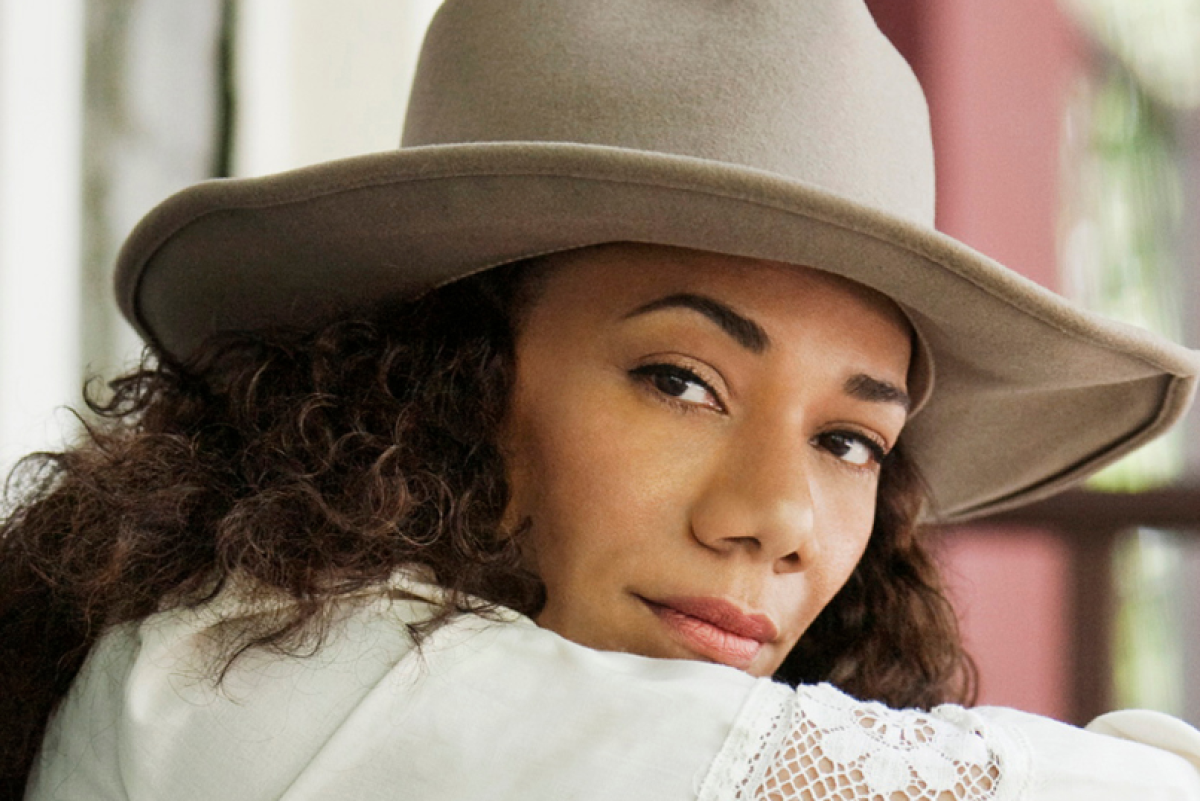 Martha Redbone in a large cream hat.