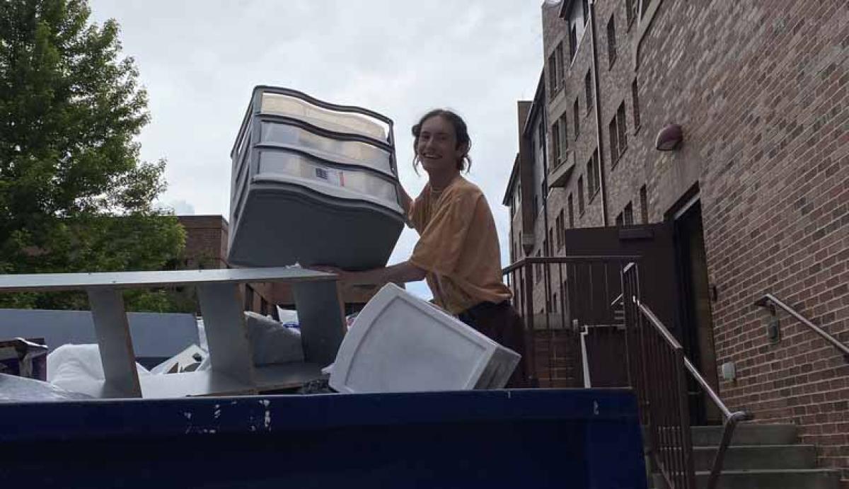 DU Sustainability Intern Jacob Tonozzi, rescuing a lightly used storage container from the dumpster last Move Out.