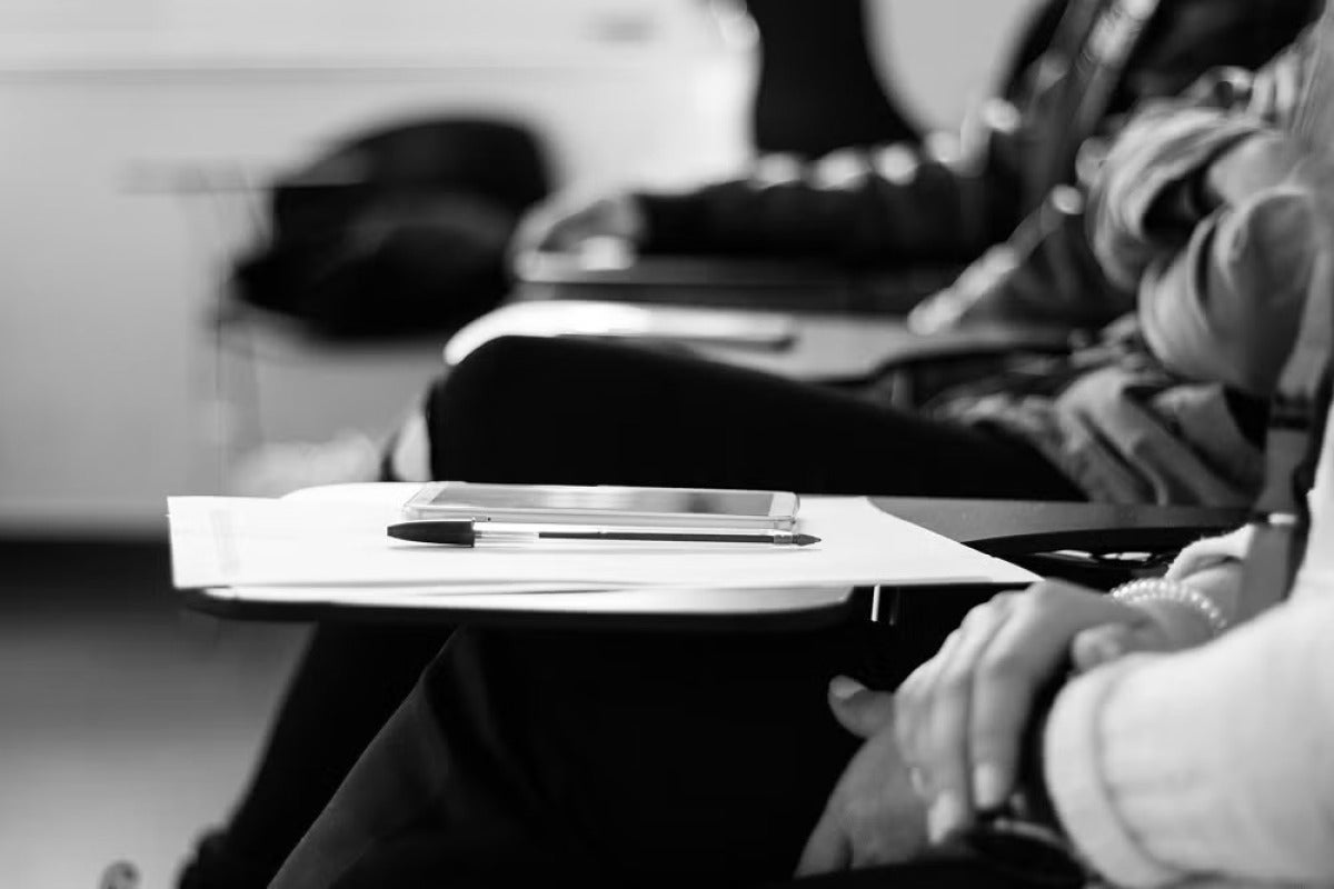pen and paper on a classroom desk
