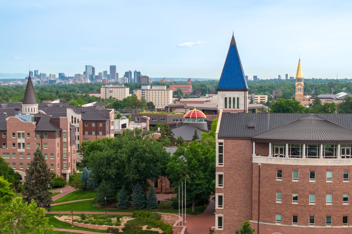 Drone shot of campus with downtown Denver in the background.
