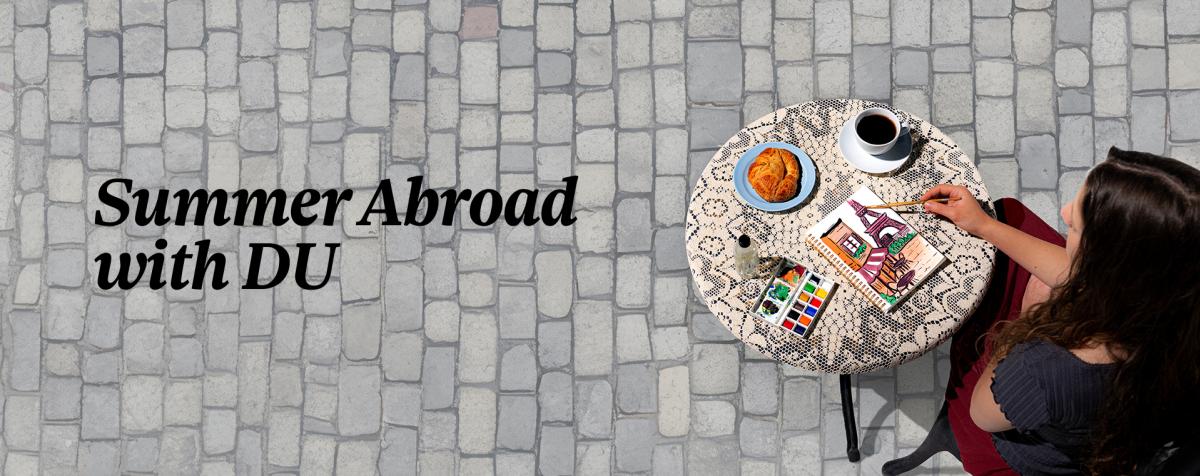 a lady sketching on her sketch book on a coffee table, text written "summer abroad with DU" on the banner