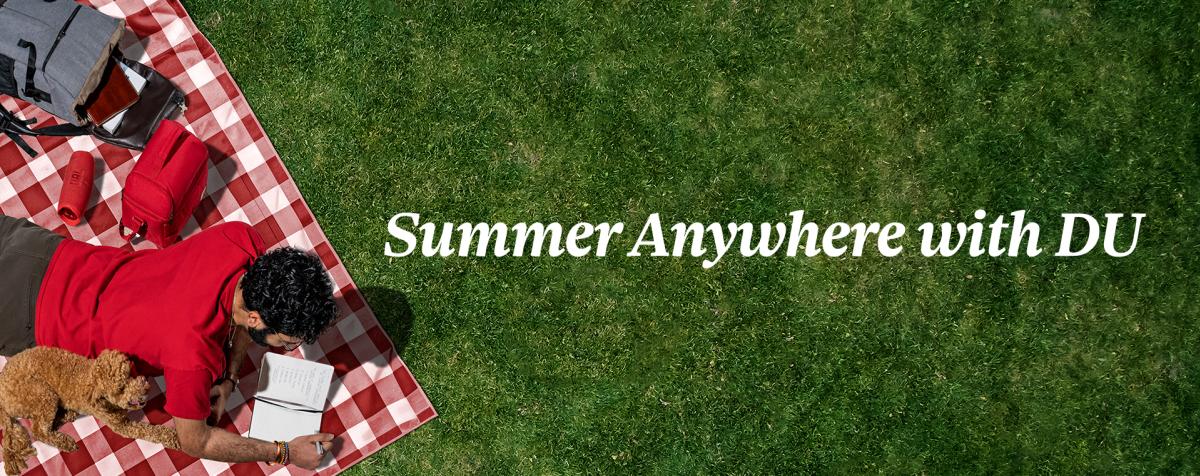 a man reading a book on a blanket on lawn, a dog is sitting next to him; text written "summer anywhere with DU" on the banner