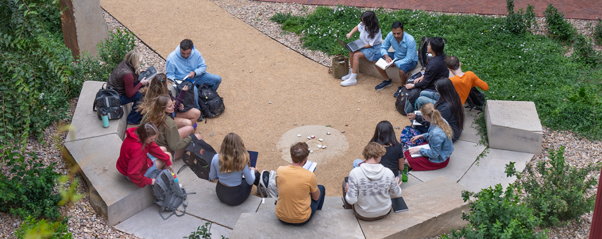 a group of students meet outside in a circular courtyard outside of Sturm building