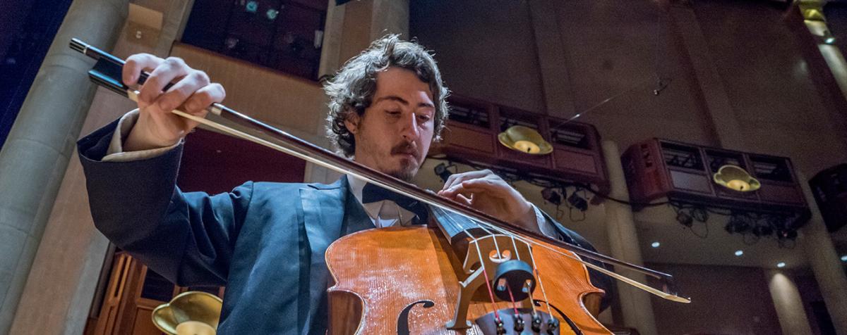 Man plays cello at a University of Denver performance
