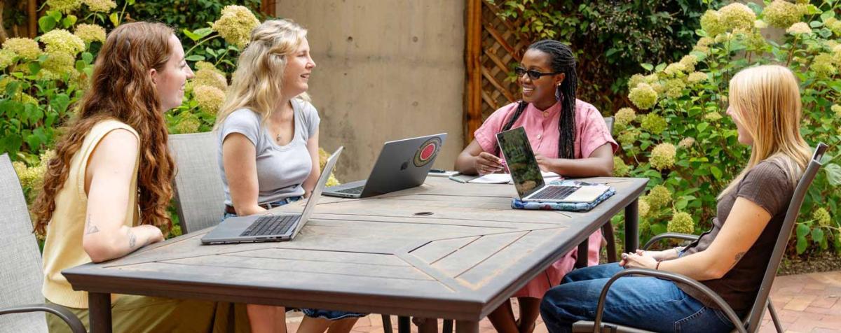 students discussing class on an outside patio