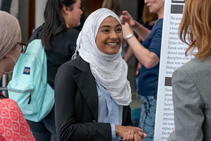 a student presents to two people at a fair