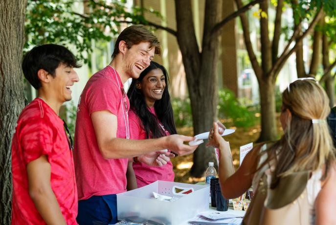 three 4D mentors greet people on move in day