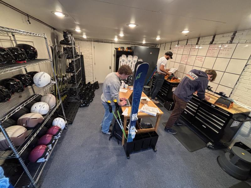 students working on their skis in the garage
