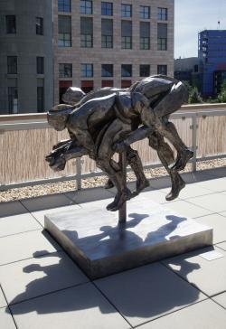 bronze sculpture of a group of bicyclists riding close together