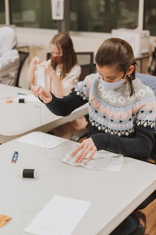 A student sews a garment at Factory Five Five.