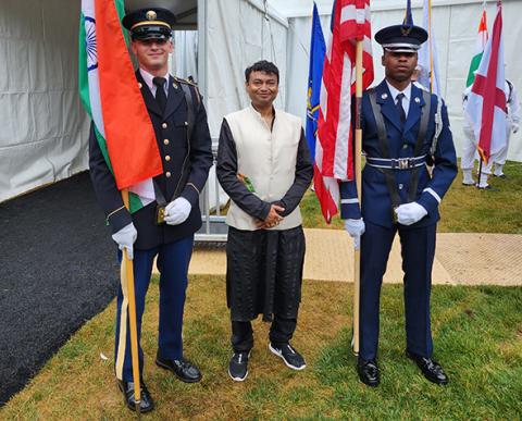 Man standing between flags
