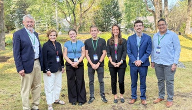 Four students pose for a group photo with three faculty members. 