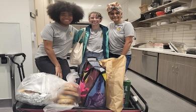 Three Colectivo de Paz volunteers preparing food in kitchen