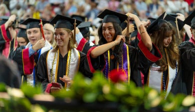 a row of students standing during commencement ceremony