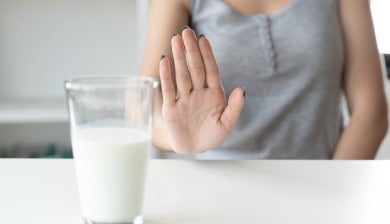 hand signals no to glass of milk on counter
