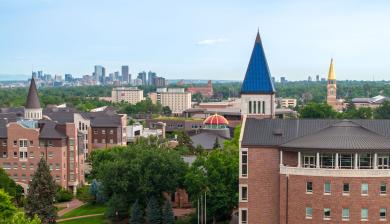 Drone shot of campus with downtown Denver in the background.