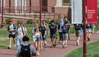 Students walking on a brick path through DU's campus