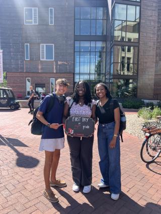 Justin stands with two students holding a sign celebrating their first day of "14th Grade" -- their sophomore year of college.