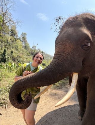 DU student Michela Schenk pets the trunk of an elephant.