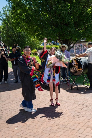 students dance outside after commencement