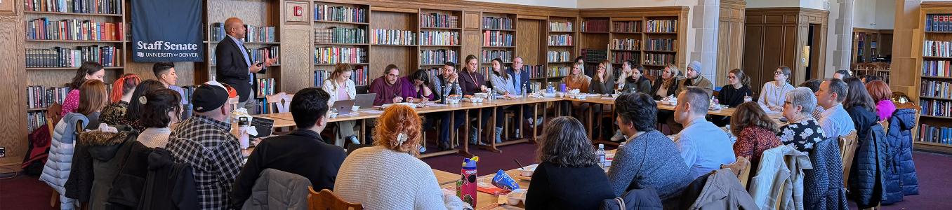Staff Senate in session, several dozen people seated around tables